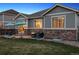 Backyard with stone patio, fire pit, outdoor seating, and manicured lawn at 25148 E Lake Pl, Aurora, CO 80016