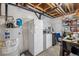 Unfinished basement with a freezer, refrigerator, and water heater at 25148 E Lake Pl, Aurora, CO 80016