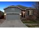 Charming stucco and stone home featuring a two-car garage and well-maintained landscaping at dusk at 25148 E Lake Pl, Aurora, CO 80016