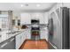 Stylish kitchen featuring white cabinets, stainless steel appliances, and hardwood floors at 25148 E Lake Pl, Aurora, CO 80016