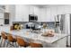 Bright kitchen with white cabinets, granite countertops, stainless steel appliances, and bar seating at 25148 E Lake Pl, Aurora, CO 80016