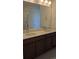 Bathroom with double sinks, dark cabinets, and a large mirror, offering ample space at 394 Grey Rock St, Brighton, CO 80601