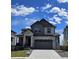 Two-story home featuring stone accents, gray siding, and a two-car garage under a cloudy sky at 394 Grey Rock St, Brighton, CO 80601