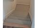 A view down a set of stairs with gray treads and white risers to the basement at 394 Grey Rock St, Brighton, CO 80601