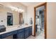 Bathroom with blue cabinets, white marble countertop and shower/toilet combo at 1095 Lake Woodmoor Dr, Monument, CO 80132