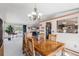 Open-concept dining room with a wooden table, view into the living room and abundant natural light at 1095 Lake Woodmoor Dr, Monument, CO 80132