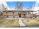 Charming two-story home with a brick and stucco exterior, mature trees, and a well-manicured lawn at 1095 Lake Woodmoor Dr, Monument, CO 80132
