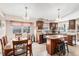 Bright kitchen featuring custom cabinets, granite counters, tile backsplash, and eat in table at 1095 Lake Woodmoor Dr, Monument, CO 80132