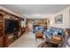 Cozy living room featuring a brick fireplace, wood paneling, and comfortable leather seating at 1095 Lake Woodmoor Dr, Monument, CO 80132