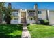 Close up of condo exterior featuring stone accents, private balconies, and lush lawn at 8555 Fairmount Dr # G103, Denver, CO 80247