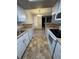 Updated kitchen features sleek white cabinets, modern appliances, and an adjacent dining area with stylish lighting at 8555 Fairmount Dr # G103, Denver, CO 80247