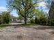 View of the home's backyard, showcasing the gravel and trees on a sunny day at 449 King St, Denver, CO 80204