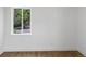 Minimalist bedroom featuring a window offering natural light and a serene view of outdoor greenery at 449 King St, Denver, CO 80204