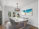Bright dining room features table, chairs, modern chandelier, and view to backyard at 449 King St, Denver, CO 80204