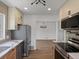 Open kitchen layout with stainless steel appliances, wood flooring, and seamless access to dining area at 449 King St, Denver, CO 80204