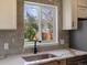 Bright kitchen featuring stylish backsplash, modern countertops, and a view of the outdoors from the window over the sink at 449 King St, Denver, CO 80204