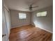 Well-lit bedroom featuring hardwood floors, a ceiling fan, two windows, and a sliding-door closet at 2991 S Whiting Way, Denver, CO 80231