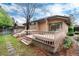 Exterior showcasing a wooden deck with steps down to the backyard and mature trees at 7500 E Dartmouth Ave # 16, Denver, CO 80231