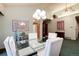 Bright dining area featuring a glass table, white chairs, and a stylish chandelier under a high ceiling at 7500 E Dartmouth Ave # 16, Denver, CO 80231