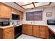 Traditional kitchen featuring oak cabinets, white tile countertops, and modern appliances for a functional cooking space at 7500 E Dartmouth Ave # 16, Denver, CO 80231