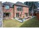Spacious brick home backyard featuring a patio with outdoor fireplace and landscaped lawn at 290 Dexter St, Denver, CO 80220