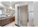 Modern bathroom featuring a double sink vanity, stylish mirrors, and a glass-enclosed shower with sleek fixtures at 290 Dexter St, Denver, CO 80220