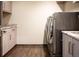 Laundry room featuring wood floors, countertops, cabinets, and modern appliances at 290 Dexter St, Denver, CO 80220