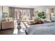 Sunlit main bedroom with sitting area, hardwood floors, and access to a private balcony at 290 Dexter St, Denver, CO 80220