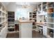 Custom walk-in closet with open shelving, drawers, a center island, makeup vanity, and decorative lighting at 290 Dexter St, Denver, CO 80220