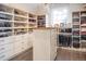 Spacious walk-in closet featuring custom shelving, drawers, a center island, and a chandelier at 290 Dexter St, Denver, CO 80220