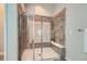 Modern bathroom with a glass-enclosed shower, tiled walls, and built-in shelving at 15852 Lavender Pl, Broomfield, CO 80023