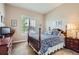 Comfortable bedroom featuring a wooden-framed bed with a plush, patterned quilt and window with shutters at 15852 Lavender Pl, Broomfield, CO 80023