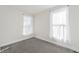 Bright bedroom featuring neutral carpet, white walls, and two windows dressed with sheer white curtains at 300 Inca St # A, Denver, CO 80223