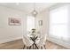 Charming dining area with a round glass table, modern chandelier, and natural light from two large windows at 300 Inca St # A, Denver, CO 80223