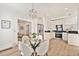 Open concept dining and kitchen area featuring stainless steel appliances, a glass dining table, and modern lighting at 300 Inca St # A, Denver, CO 80223
