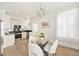 Well-lit kitchen and dining area showcasing white cabinets, stainless steel appliances, and modern lighting fixtures at 300 Inca St # A, Denver, CO 80223