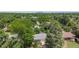 Aerial view showcasing the property nestled among mature trees with a glimpse of the cityscape in the distance at 2440 Saulsbury St, Lakewood, CO 80214