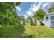 Lush backyard with a manicured lawn, mature trees, garden area, and storage shed at 2440 Saulsbury St, Lakewood, CO 80214
