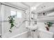 Clean bathroom with white tiled walls, a glass-enclosed shower, and classic fixtures at 2440 Saulsbury St, Lakewood, CO 80214