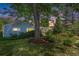 Charming home exterior featuring a well-maintained lawn, vibrant garden beds, and mature trees at 2440 Saulsbury St, Lakewood, CO 80214