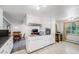 Open kitchen with white cabinets, dining area, and natural light at 2440 Saulsbury St, Lakewood, CO 80214