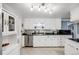 Bright kitchen featuring white cabinetry, stainless steel appliances, and tile flooring at 2440 Saulsbury St, Lakewood, CO 80214