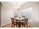Bright dining room with a square dining table set under a modern chandelier at 8465 Pebble Creek Way # 102, Highlands Ranch, CO 80126