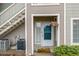 Charming entryway with a teal door, hanging flowers, and exterior stairs to upper units at 8465 Pebble Creek Way # 102, Highlands Ranch, CO 80126