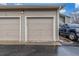 Attached two car garage featuring beige doors and a blue truck parked to the side at 8465 Pebble Creek Way # 102, Highlands Ranch, CO 80126