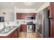 Efficient kitchen with stainless steel appliances, wood cabinets, and a bright, clean aesthetic at 8465 Pebble Creek Way # 102, Highlands Ranch, CO 80126