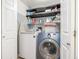 Efficient laundry room with front loading washer and dryer, shelving and storage at 8465 Pebble Creek Way # 102, Highlands Ranch, CO 80126