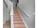 Light-filled stairway featuring wood steps, white risers and handrail, and neutral paint tones at 13000 W Grant Cir # C, Thornton, CO 80241
