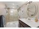 Modern bathroom showcasing a tiled shower with glass door and a vanity with elegant mirror at 929 Coneflower Dr, Golden, CO 80401