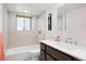 Bright bathroom with a shower-tub combo, sleek vanity, tiled walls, and modern fixtures at 929 Coneflower Dr, Golden, CO 80401